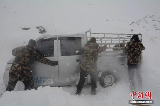 12日，新疆阿勒泰邊防官兵在救援被困車輛。（圖片來源：中新網(wǎng)）