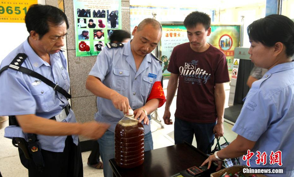 資料圖：7月29日，公安民警和安保人員正在克拉瑪依客運(yùn)站進(jìn)站口嚴(yán)查進(jìn)站旅客行李和違禁物品。 周建玲 攝