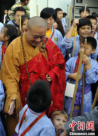 圖為少林寺釋永信方丈與參加武術(shù)交流的兒童們交談。中新社發(fā) 毛建軍 攝