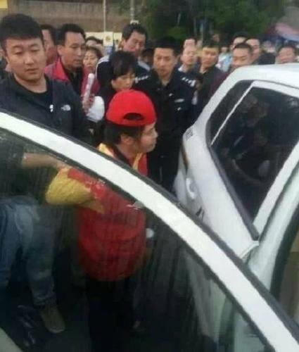 女志愿者被民警帶上警車，受傷女子則被送醫(yī)救治。