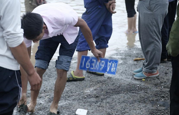 道路積水嚴(yán)重村民水中撈車牌賣錢-一個(gè)要價(jià)100元3