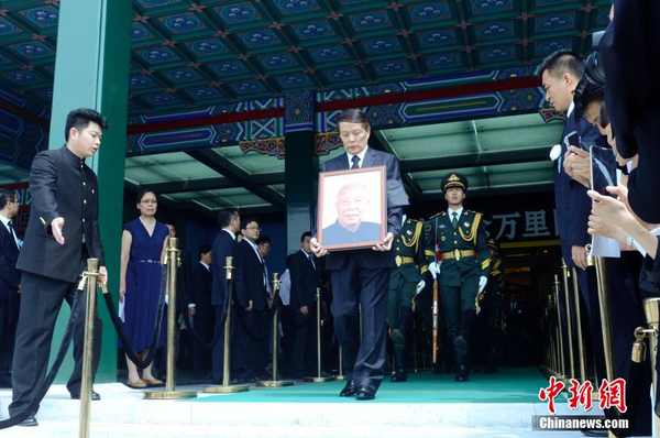 7月22日，萬里遺體在北京火化，社會各界人士前往八寶山殯儀館進(jìn)行悼念。圖為萬里兒子萬伯翱手捧遺像步出。 中新社發(fā) 盛佳鵬 攝