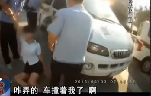 在拉扯中，女子撞到警車上。