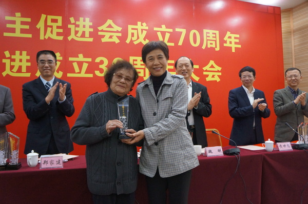 廈門市統(tǒng)戰(zhàn)部部長黃菱給入會60周年97歲高齡的民進會員謝植桂頒發(fā)榮譽獎杯。