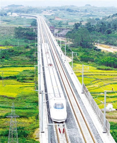 　12月3日，一輛試運行的“和諧號”列車從廣西南寧市隆安縣境內(nèi)的一座高架橋經(jīng)過。韋萬忠攝（新華社發(fā)）