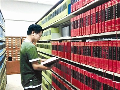 資料圖：一名古籍愛好者正在北大古籍閱覽室翻看“四庫全書”。圖片來源：北京青年報(bào)