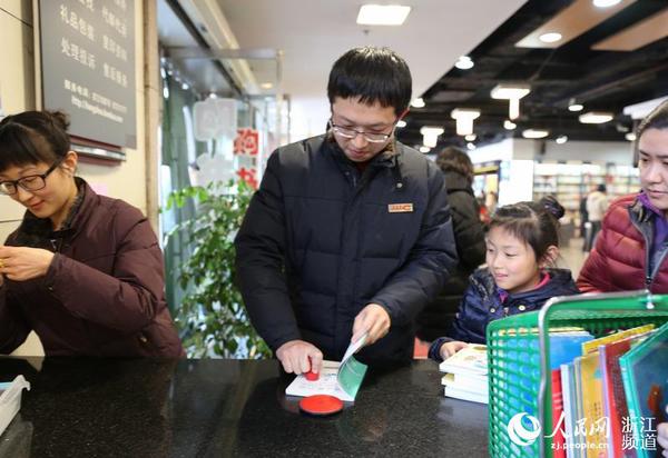 圖書管理員給新書加蓋杭州圖書館公章。