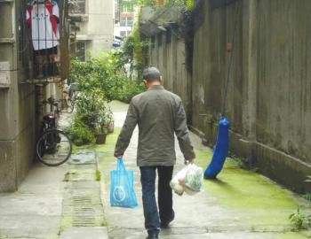 成都某中學(xué)外的小區(qū)內(nèi)，一家長用中午空閑時間給住在這里的孩子買菜做飯。