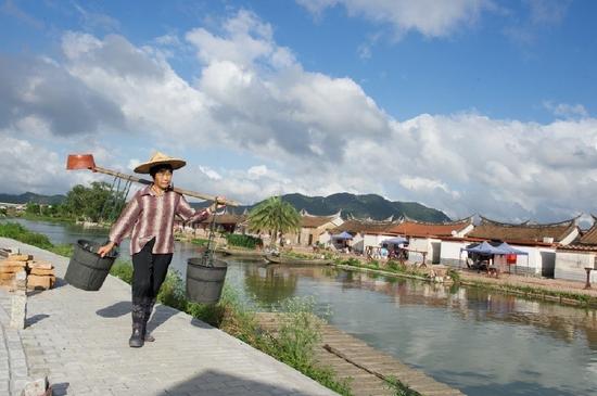 5月27日，埭美村一位村民挑桶經(jīng)過村前小河