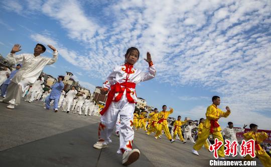 少年太極拳愛(ài)好者在江西都昌縣一廣場(chǎng)上表演太極拳?！「到ū蟆z