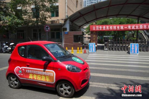 一輛新能源電動(dòng)汽車高考接送車從山西太原某考點(diǎn)前駛過。<a target='_blank' href='http://www.chinanews.com/'>中新社</a>發(fā) 張?jiān)?攝