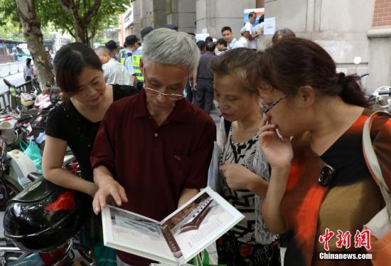 資料圖：幾位杭州市民欣賞已買到的“G20杭州峰會(huì)明信片”。 中新社記者 王剛 攝