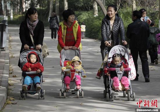 資料圖：2013年11月15日，河南鄭州幾位家長推著嬰兒車走過鄭州街頭。中共十八屆三中全會審議通過了《中共中央關(guān)于全面深化改革若干重大問題的決定》，《決定》提出，啟動實(shí)施一方是獨(dú)生子女的夫婦可生育兩個孩子的政策。<a target='_blank' href='http://www.chinanews.com/'>中新社</a>發(fā) 王中舉 攝