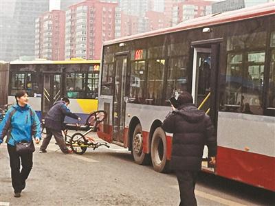 昨天晚高峰時(shí)段，兩輛共享單車“掛上”公交車 攝影/本報(bào)記者 屈暢