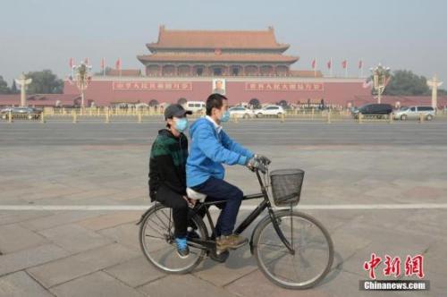 資料圖：一對(duì)青年佩戴口罩騎車經(jīng)過北京天安門廣場。 <a target='_blank' href='http://www.chinanews.com/'>中新社</a>記者 崔楠 攝