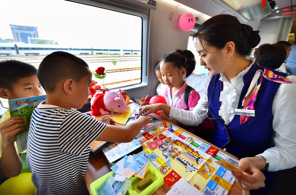 北京鐵路局天津客運(yùn)段值乘的廈門北至北京南G324次列車乘務(wù)員與兒童旅客互動(dòng)做游戲。