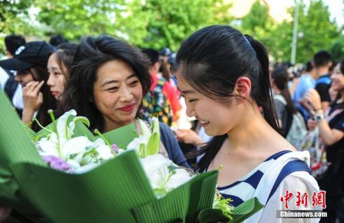 資料圖：山東濟(jì)南眾多考生手捧鮮花在家長(zhǎng)的簇?fù)硐職g快告別高考。<a target='_blank' href='http://www.chinanews.com/' _fcksavedurl='http://www.chinanews.com/'></table>中新社</a>記者 張勇 攝