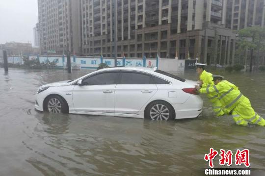 圖為：周宇和隊(duì)員在水中推拋錨的車。 金華公安供圖