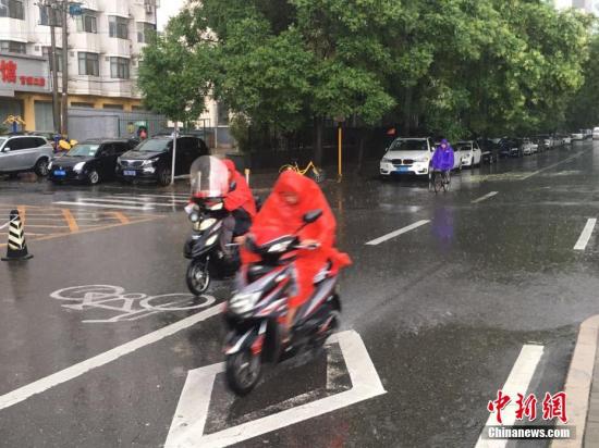 6月23日清晨，北京降雨持續(xù)，并出現(xiàn)了短時(shí)大雨。據(jù)北京市氣象局官方微博消息，北京市氣象臺今日6時(shí)發(fā)布：今天白天小到中雨并伴有雷電，傍晚局地伴有短時(shí)大風(fēng)或冰雹，北轉(zhuǎn)東風(fēng)2、3級，最高氣溫24℃；夜間有雷陣雨，東轉(zhuǎn)北風(fēng)2、3級，最低氣溫19℃。圖為北京阜成路，市民雨中騎行。 <a target='_blank' href='http://www.chinanews.com/' >中新網(wǎng)</a>記者 富宇 攝