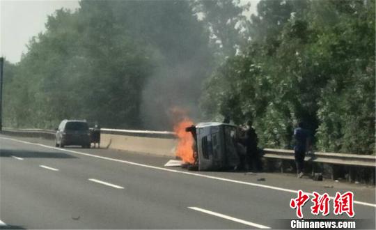 圖為：杭甬高速寧波段一輛面包車側(cè)翻后起火，好心人救一家7口。　何蔣勇 攝