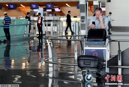 此前，阿聯(lián)酋航空、埃及航空等相繼暫停往返卡塔爾首都多哈的航班，沙特等國甚至禁止卡塔爾航空班機(jī)越過領(lǐng)空，令中東航空樞紐多哈的哈馬德國際機(jī)場陷入混亂。圖為一名游客在哈馬德國際機(jī)場看手機(jī)。