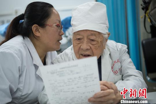 問診時，她的助手王利花趴在于載畿耳朵旁當“傳聲筒”，書寫病歷時，于載畿用尺子比著。　武俊杰 攝