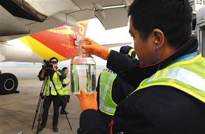 11月21日，首都國際機(jī)場，工作人員展示生物航煤。新華社發(fā)