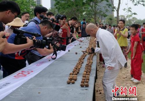 黎偉軍手劈核桃現(xiàn)場吸引不少人圍觀?！〕叹皞?攝