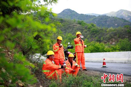 臨近中午，楊衛(wèi)東和工友們在路旁休息時，拿出自帶的干糧和水補充體力?！⒗^東 攝