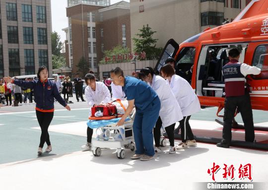 5月23日，遼寧省人民醫(yī)院完成中國東北首例異地航空醫(yī)療轉(zhuǎn)運任務。圖為急救人員立即將患者抬上急救床?！≈烀饔?攝