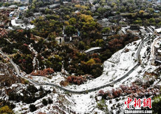 11月4日早晨，航拍視角中的蘭州城區(qū)一角，繽紛秋色中點(diǎn)綴著點(diǎn)點(diǎn)白雪?！钇G敏 攝