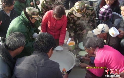 官兵在營地與災(zāi)民共同吃飯。武警玉樹支隊 趙飛 供圖