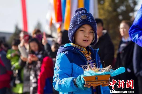 圖為小孩拿著貢品準(zhǔn)備祭火。　胡杰 攝