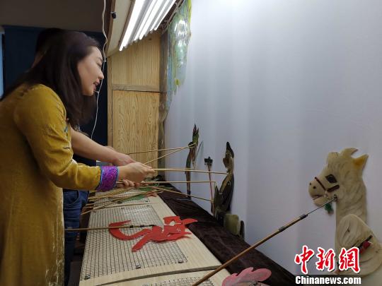 李娟藏在幕布后，繪聲繪色地為觀眾表演《西游記之孫悟空大戰(zhàn)蝎子精》?！≮w曉 攝