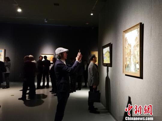 圖為，在“印象山東——俄羅斯油畫家寫生作品展”上，觀眾在喜歡的作品前駐足觀賞、拍照?！O宏瑗 攝