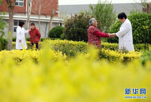 5月5日，在河北省衡水市桃城區(qū)一家養(yǎng)老康復醫(yī)療中心，護工在陪老人散步。新華社記者 牟宇 攝