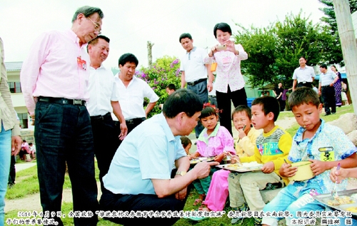 2014年6月9日，全國政協(xié)“推進農(nóng)村義務(wù)教育學(xué)生營養(yǎng)改善計劃貫徹實施”委員視察團在云南視察。圖為委員實地察看孩子們的營養(yǎng)餐情況。  本報記者 廉維亮 攝