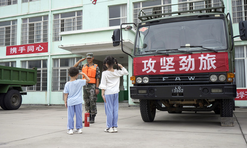 圖為在學(xué)校宿營點(diǎn)，小學(xué)生向抗洪官兵官兵敬禮表達(dá)謝意的畫面。（付少旋）