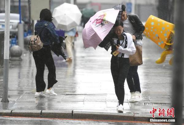 資料圖：市民頂風(fēng)冒雨出行。 中新社記者 張瑤 攝